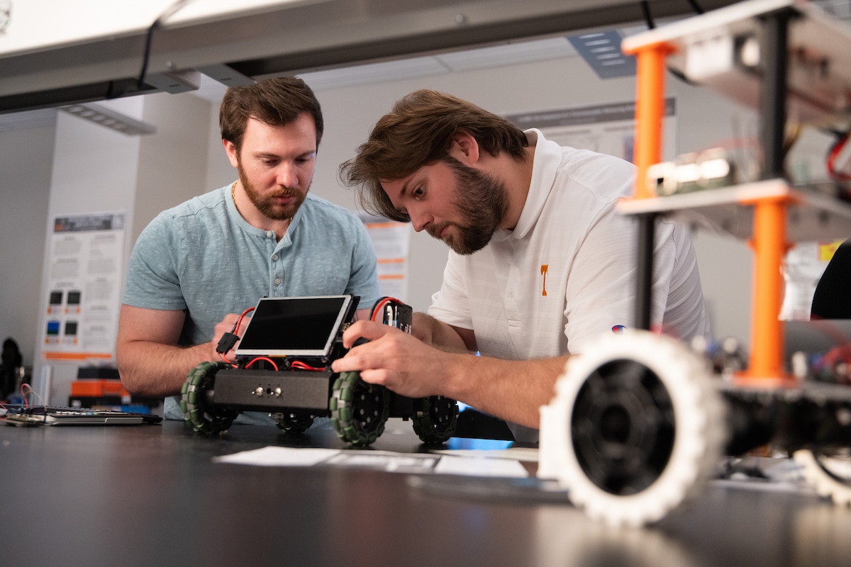 Graduate students Adam Foshie and Charles Rizzo work on autonomous vehicle GRANT (Ground Roaming Autonomous Neuromorphic Targeter) in a neuromorphic computing lab