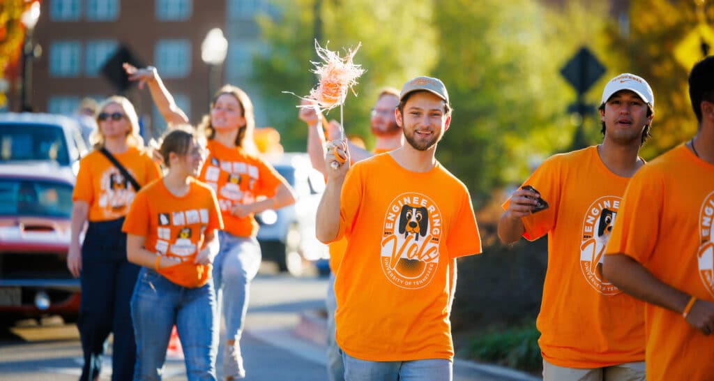 Engineering Vols wave while walking in the Homecoming Parade along Volunteer Blvd
