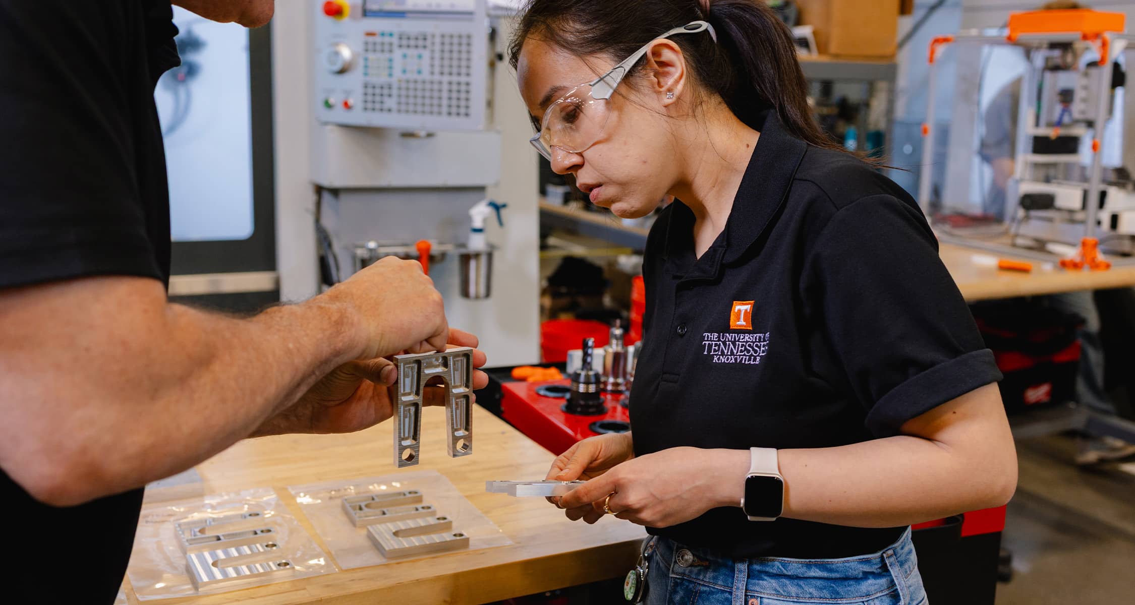 Graduate student looks at piece of equipment machined at TN-MADE