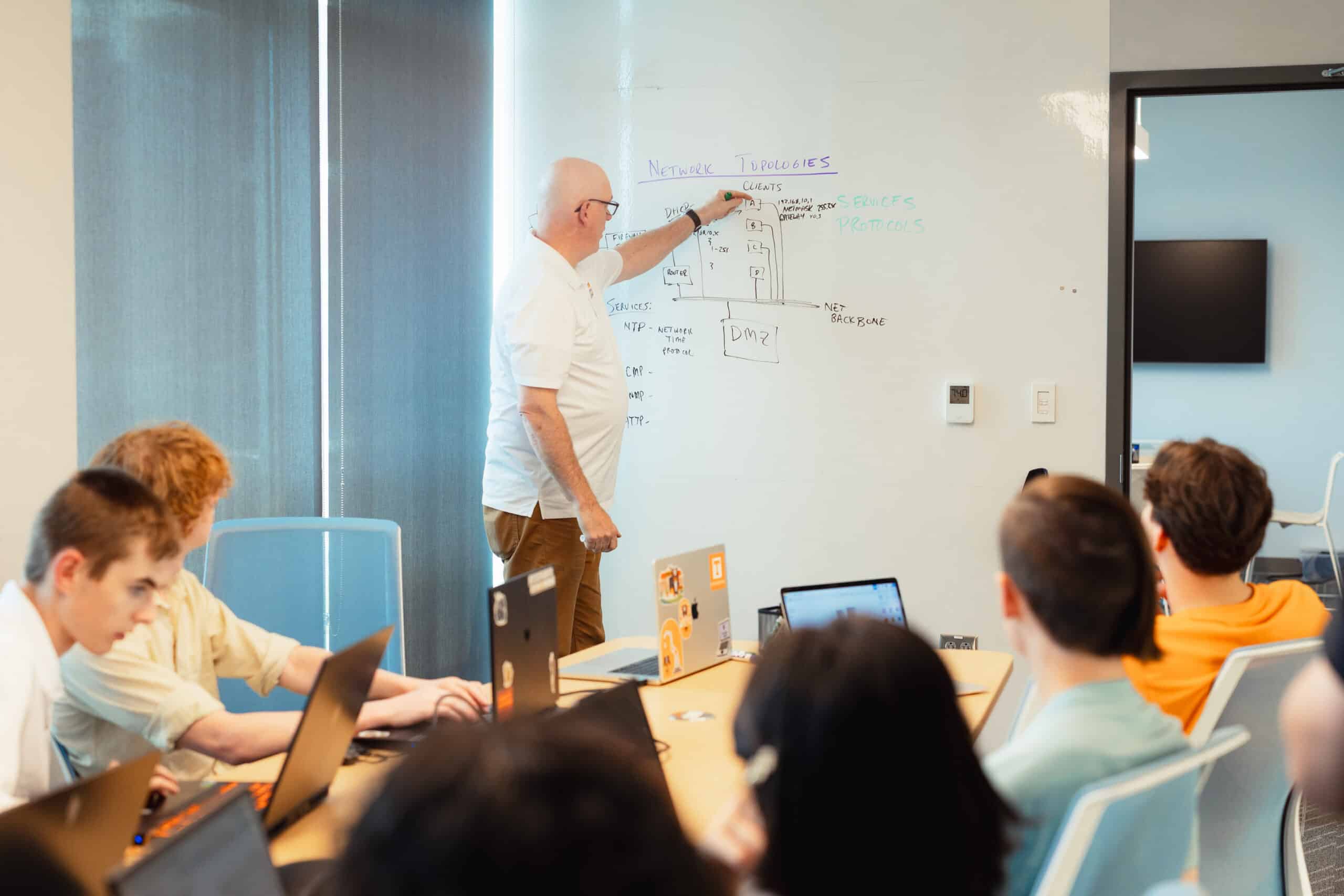Assistant Professor of Practice Brian LaRose writes on a whiteboard during a class