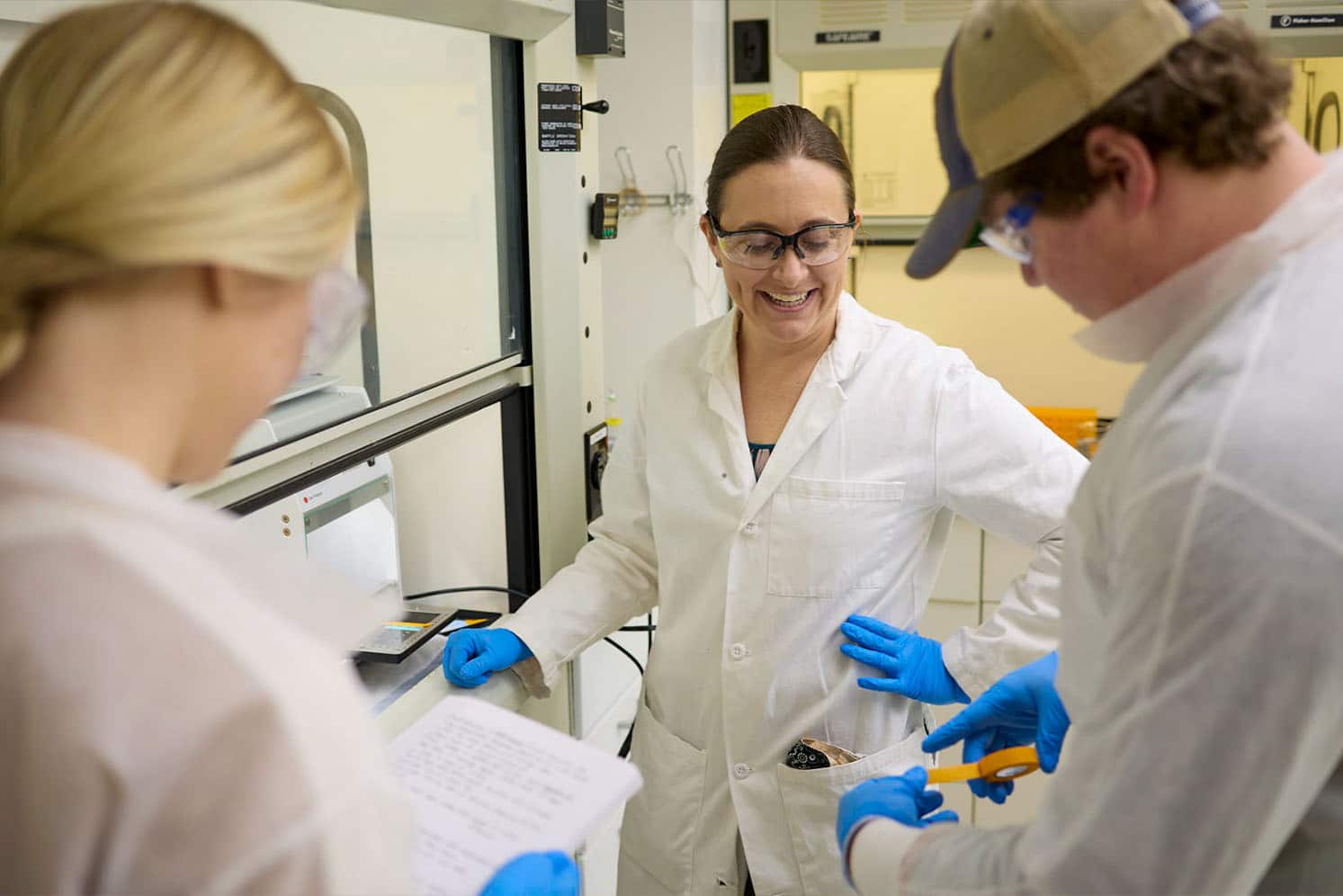 Two students work in research lab with Colleen Crouch