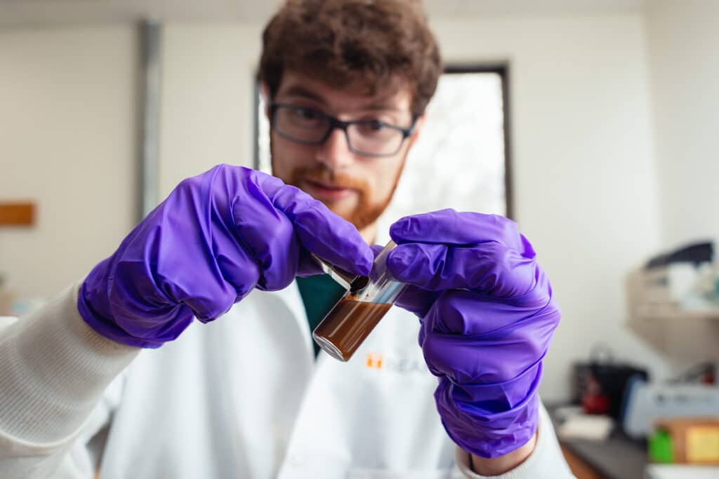 Grad student works with specimen in UTSI lab. 
