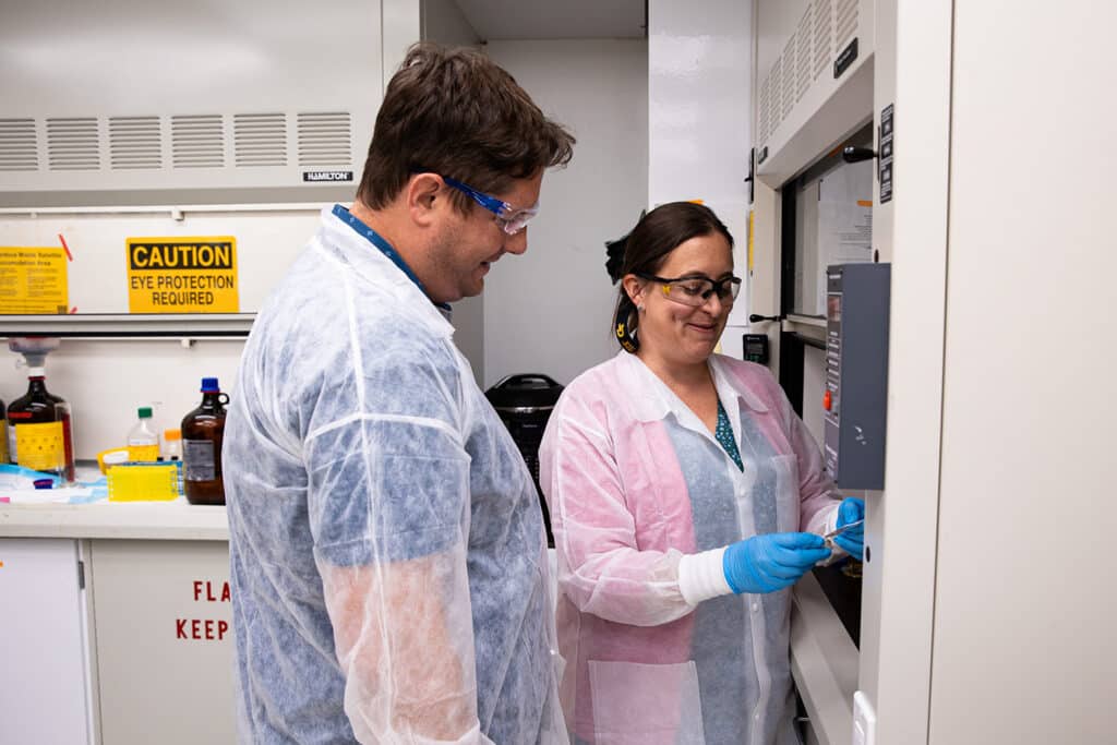 Bryan Good and Colleen Crouch examining a specimen in their lab.