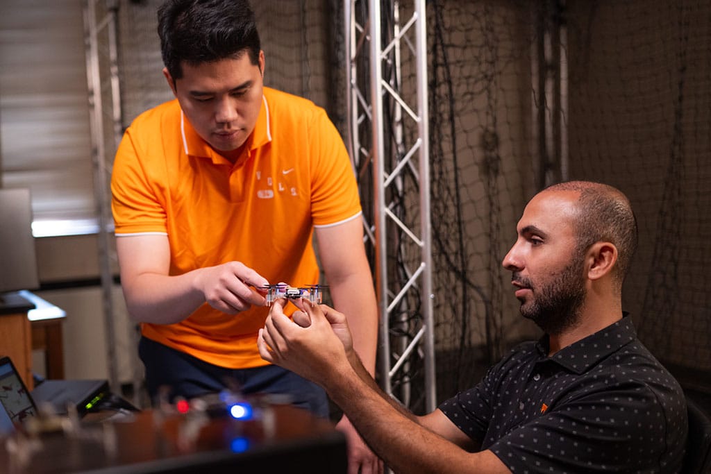Two aerospace engineering students work with a drone. 