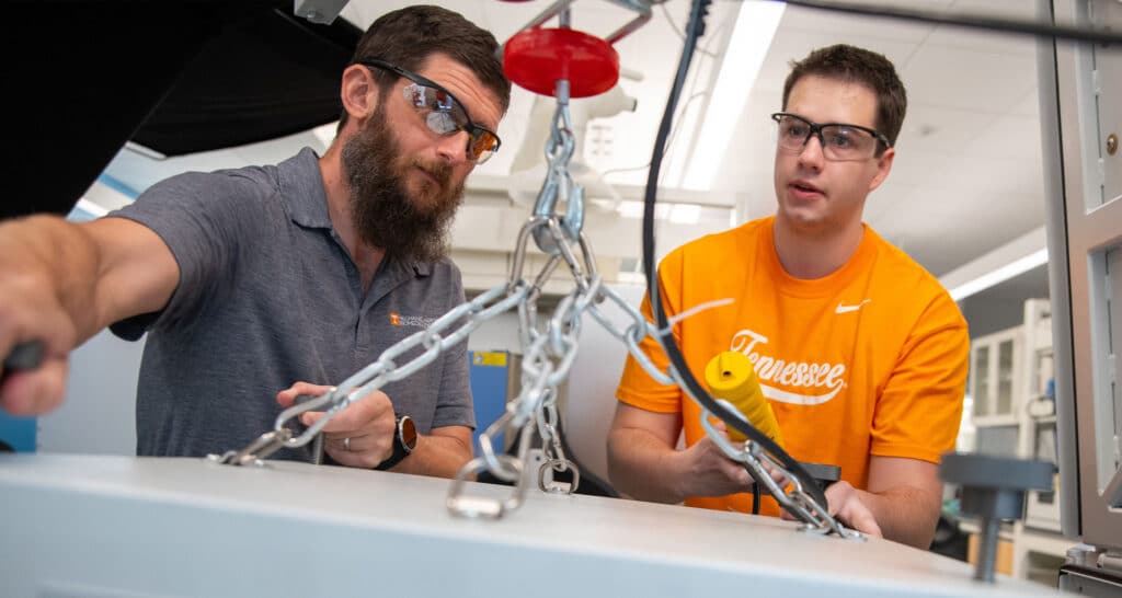 Doug Aaron works inside the ARC Battery Lab with a graduate student
