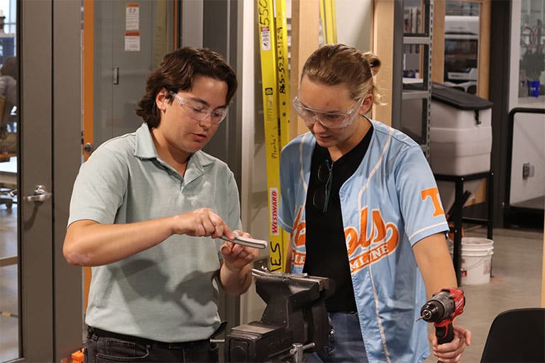 Anukkah Burleson and another student work on a metal part for the bass drum at the ICS.