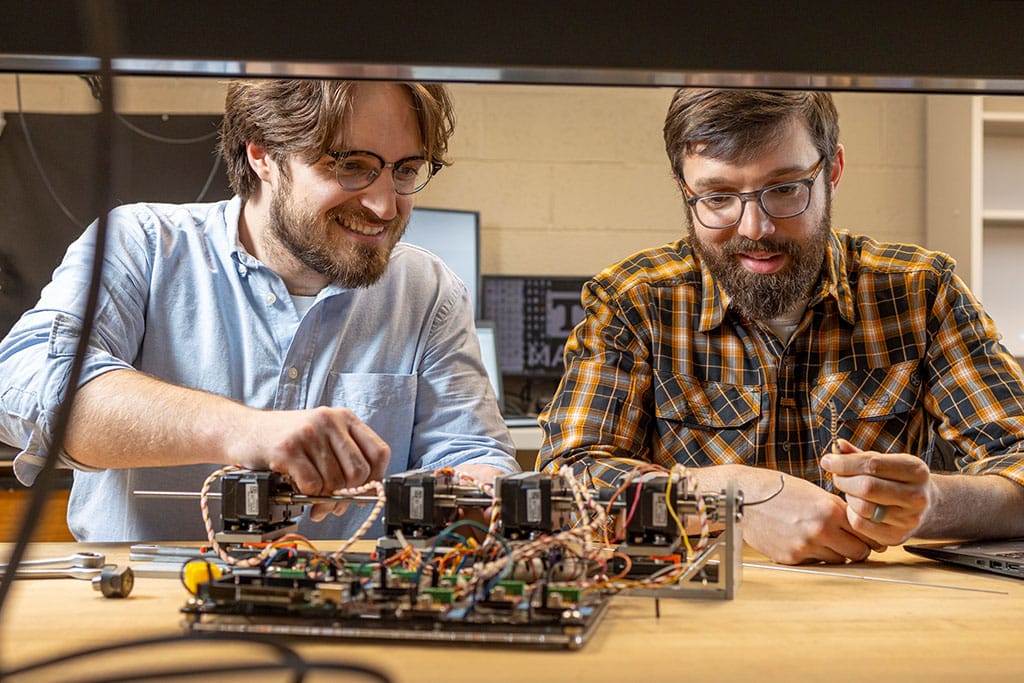 Caleb Rucker works with student in research lab