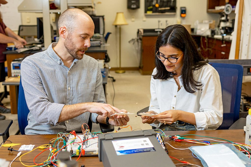 Andy Sarles works with a grad student in his lab. 