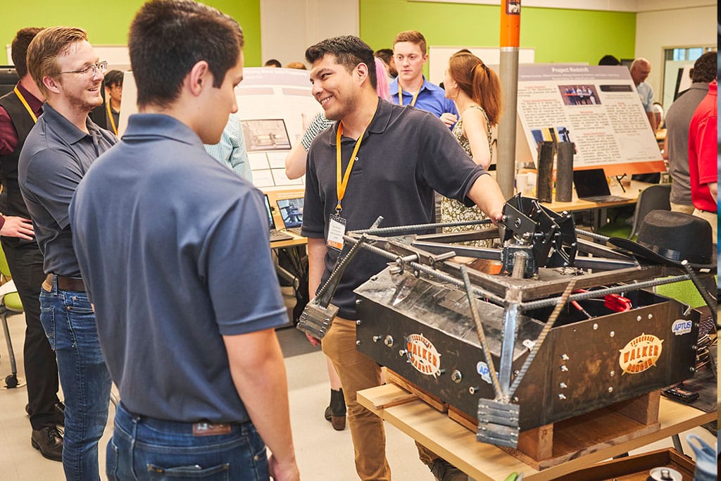 Student design team discusses their robot during senior design.