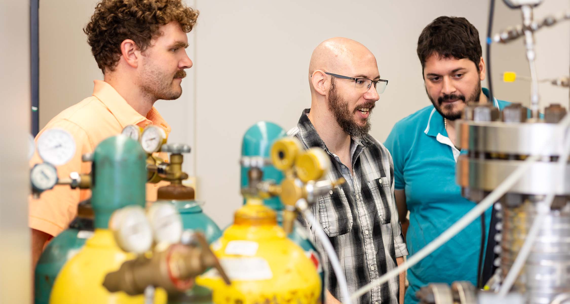 Three students working inside mechanical engineering research lab in SERF