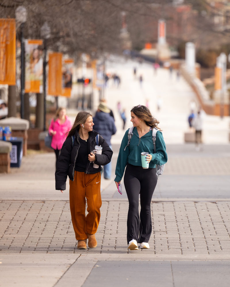 Students visit while walking up Ped Walkway during the first day of Spring classes