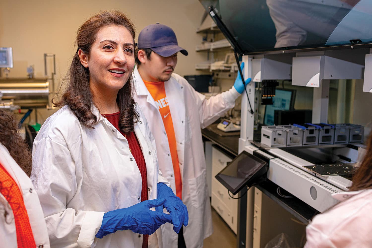 Mahshid Ahmadi and students wearing lab coats in an IAMM lab.