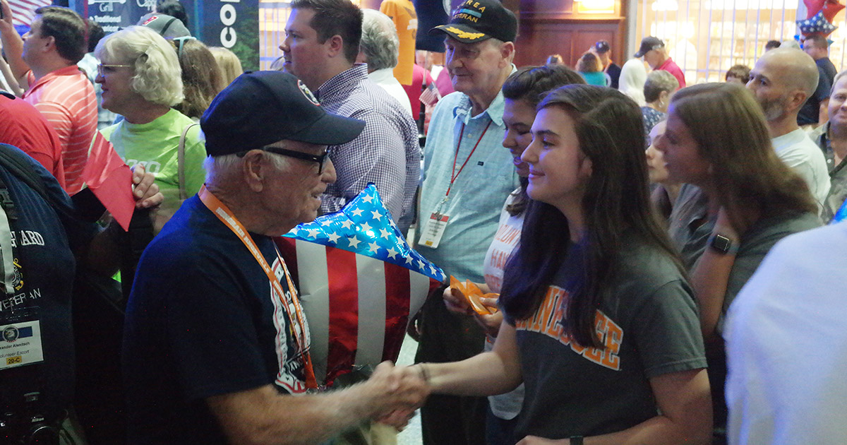 Elizabeth Sutton shakes the hand of a veteran in the airport.