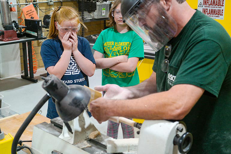 Michael Allen demonstrates woodworking tools to students at STEM Camp.