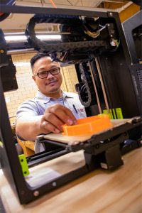 Tom Duong working with 3D Printer