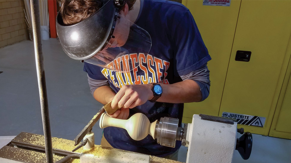Male student using wood lathe