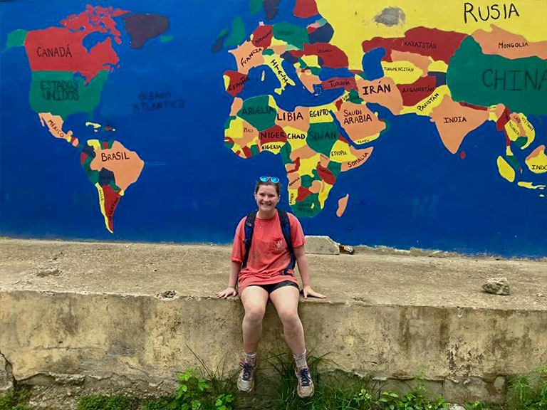 Courtney Nakamura sits in front of mural in the Dominican Republic