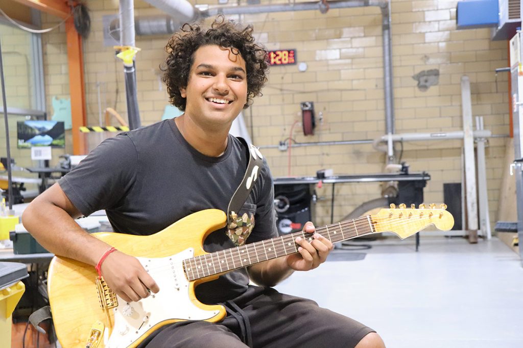 Alumnus Mitul Mistry plays of of the electric guitars he built in the Innovation and Collaboration Studio.