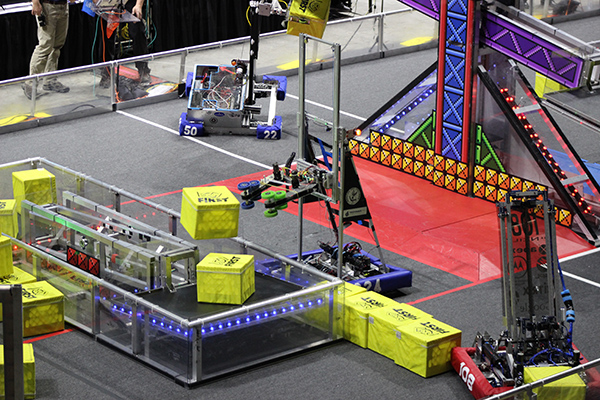 Competitors guided their machines to load items onto various scales on the arena floor.