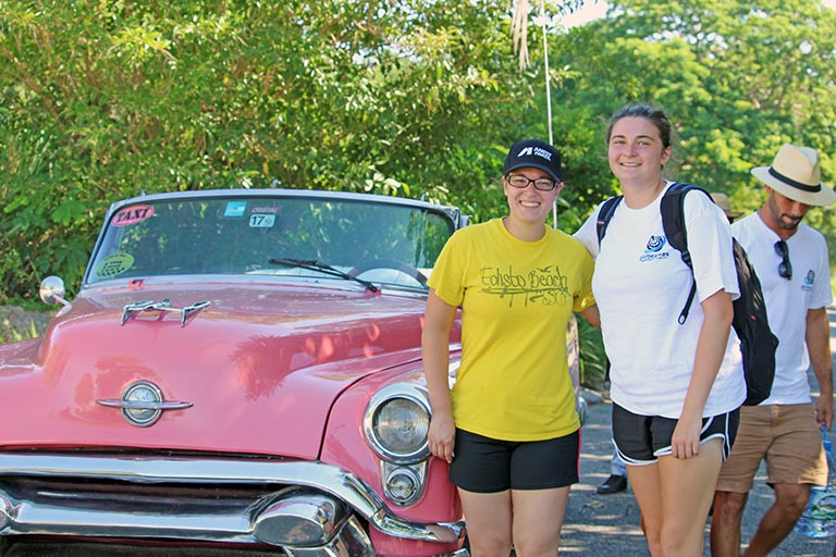 Nicole Gonzalez and Caitlin Harpell exit the classic car at the worksite