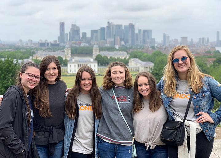 Six students in front of a city.