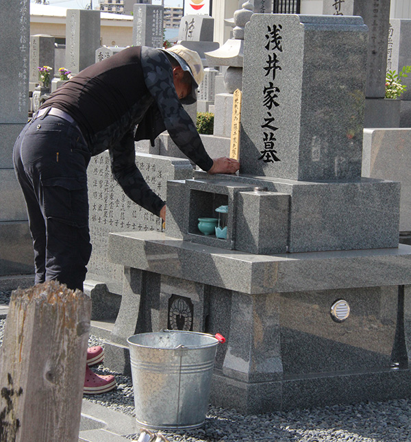 local man cleaning gravestone for the Bon celebration