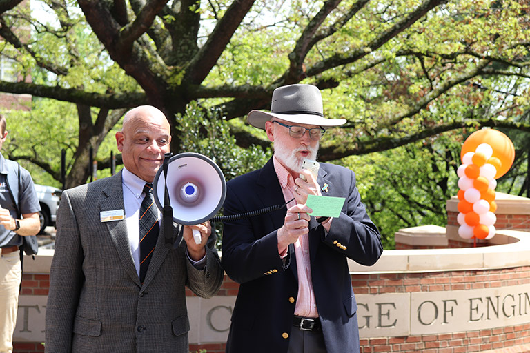Mark Dean assists Associate Dean Bill Dunne in presenting the college’s new brick wall sign to the Board of Advisors.