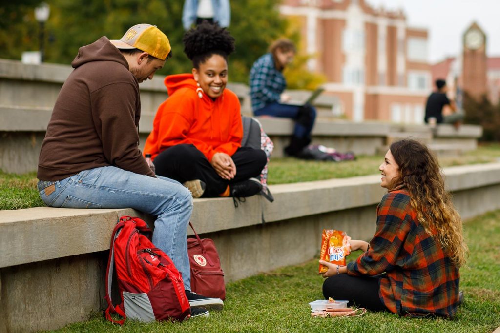 Students sits in the ampitheatre on campus between classes