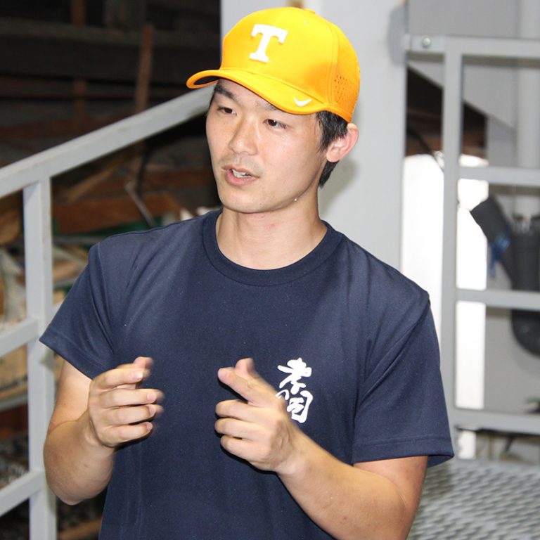 The brewmaster at the sake distillery wearing a University of Tennessee hat.