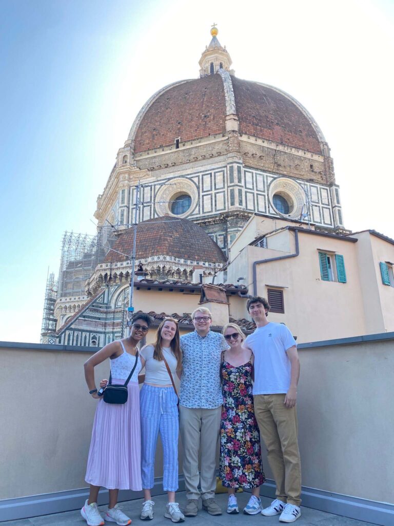 Students posing together in front of Italian building