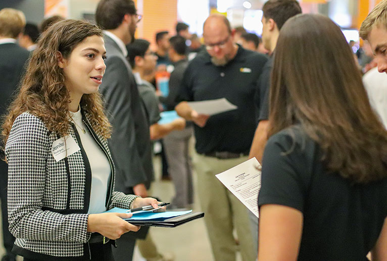 Sophomore industrial engineering student Jenifer Rodriguez, left, talks to a pair of recruiters during the expo.