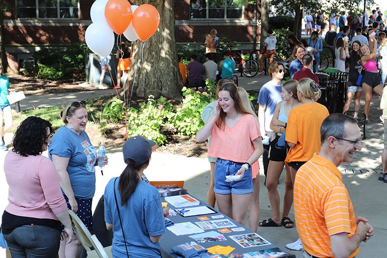 Student talking to representatives at a booth in the courtyard