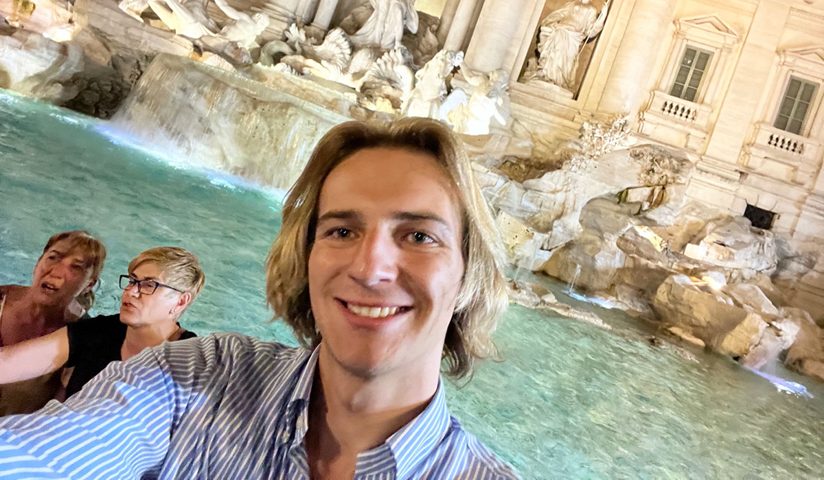 Ethan Andes in front of a fountain in Italy.