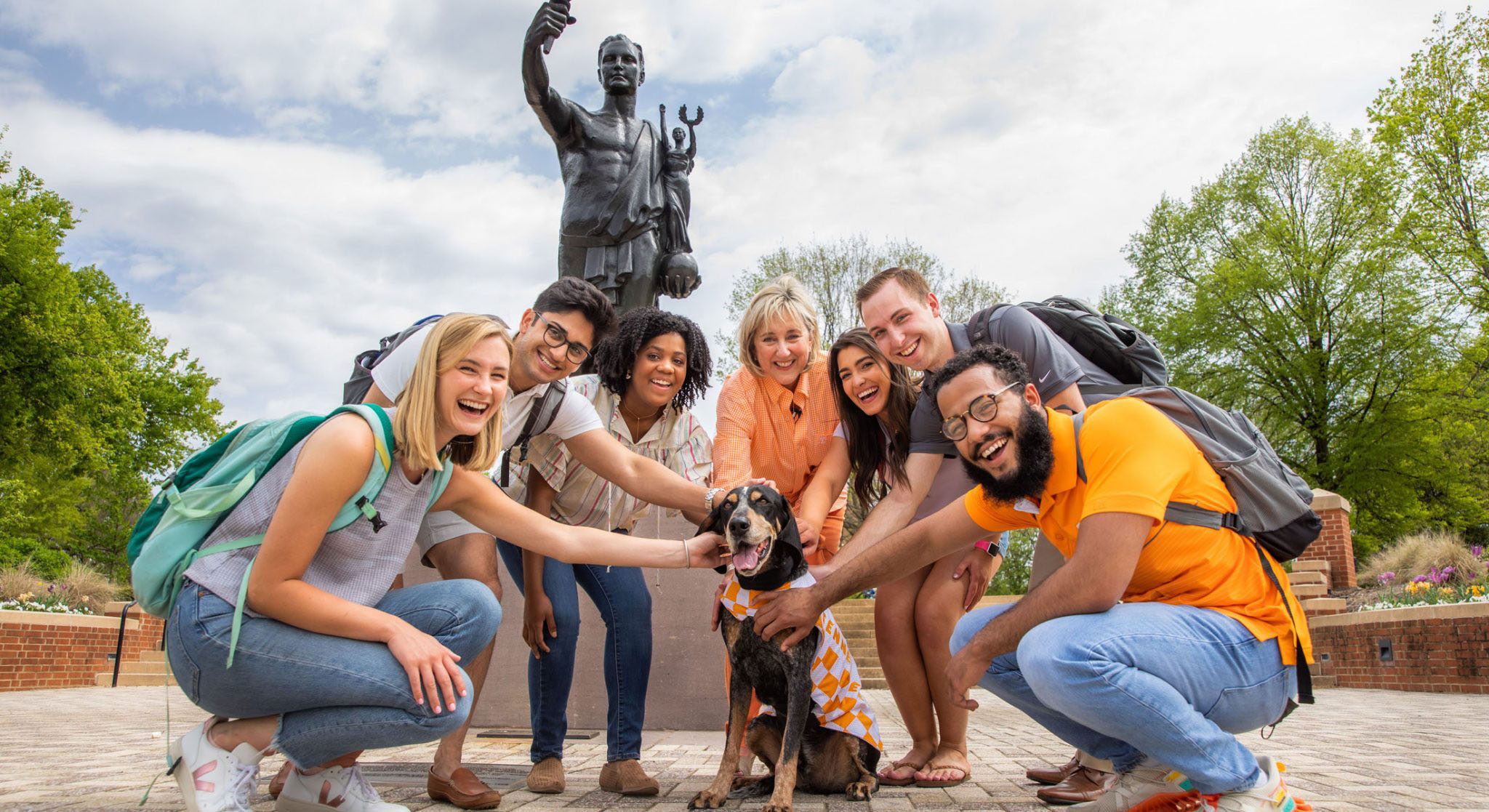Students and the chancellor posing with Smoky the dog