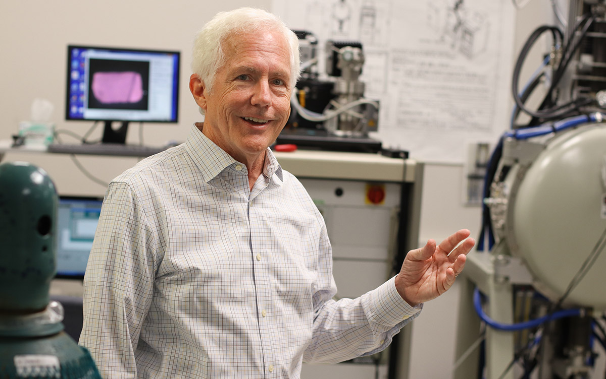 Scintillation Materials Research Center Chuck Melcher stands in front of equipment used for research at the center