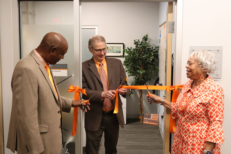 Harold Conner, Paul Frymier, and Joyce Conner cut ribbon to office.  