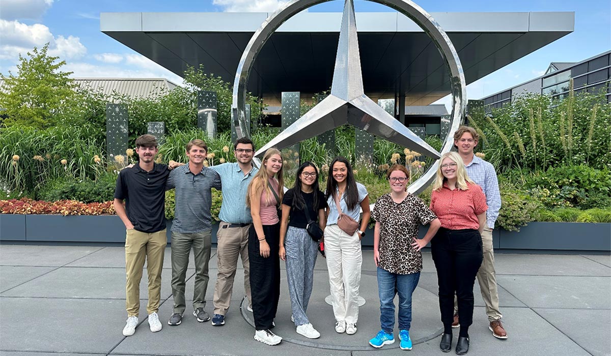 Drake Dessecker and other Cooks Grand Challenge Honors students stand in front of the Mercedes Benz factory in Zurich.