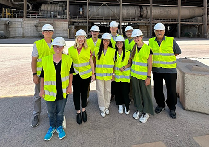 Rachel Cheek and other students of the Switzerland study abroad group stand together in a group dressed in neon yellow safety vests and white hard hats.
