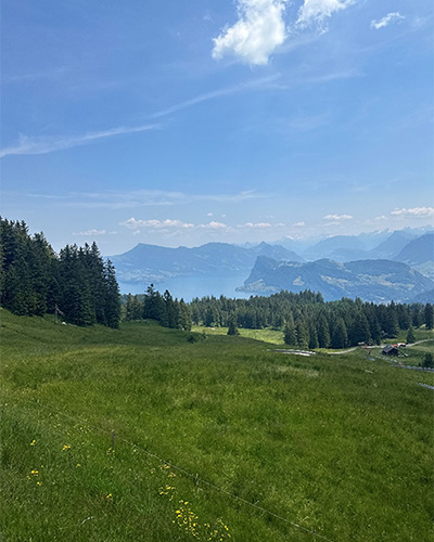A scenic view of mountainous and rolling landscape with blue skies in Zurich.