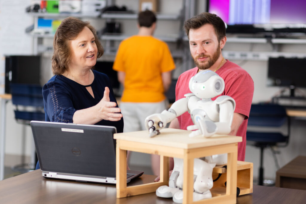 Lynne Parker and a student working on a robot in a lab