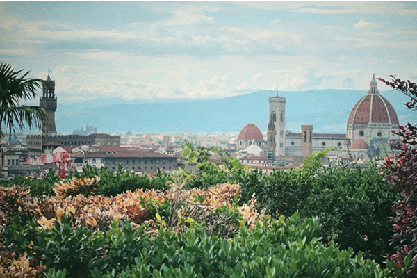 Florence, Italy with a church, old buildings, and mountains in the background