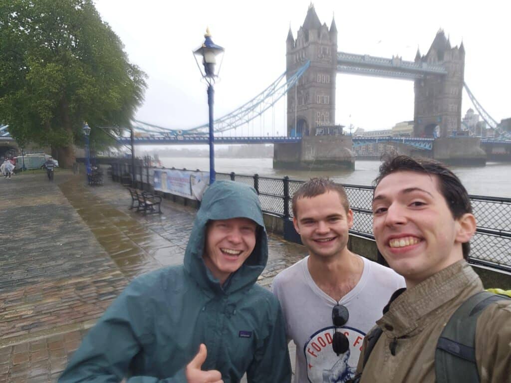 Daniel Metcalf and a couple of friends standing on the street in London, England with the London Bridge in the background