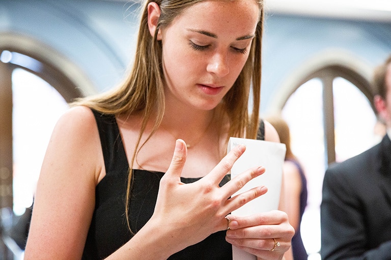 Graduate places the order of the engineering ceremony ring on their finger