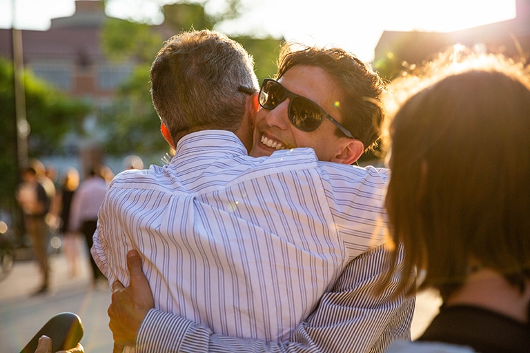 Graduate hugs a family member after the ceremony,