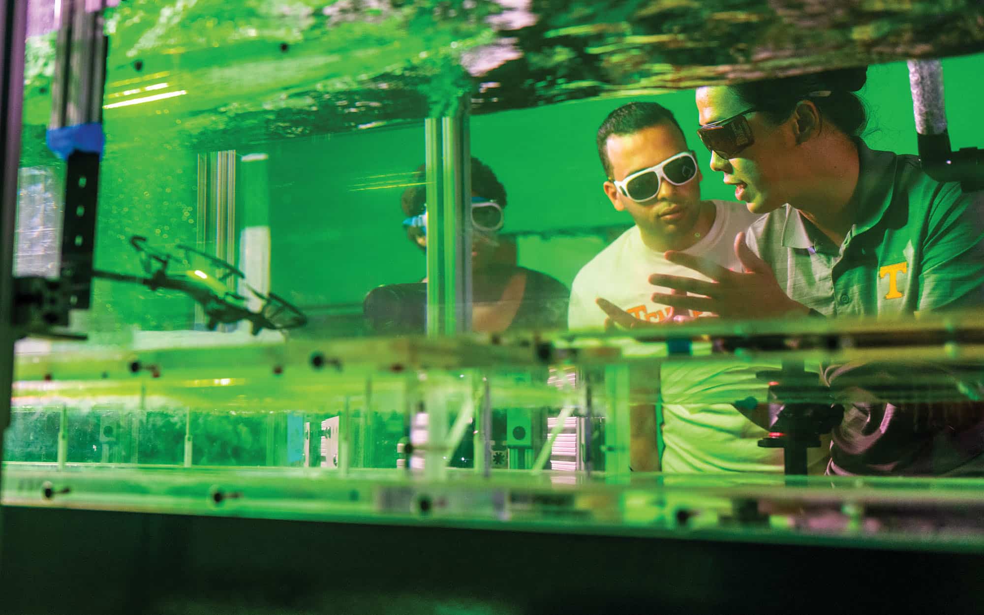 Assistant Professor Haochen Li and students Leila Kelly and Mohamed Shatarah use a flume to study and better predict aerodynamic performance of drones in the Water Infrastructure Lab.