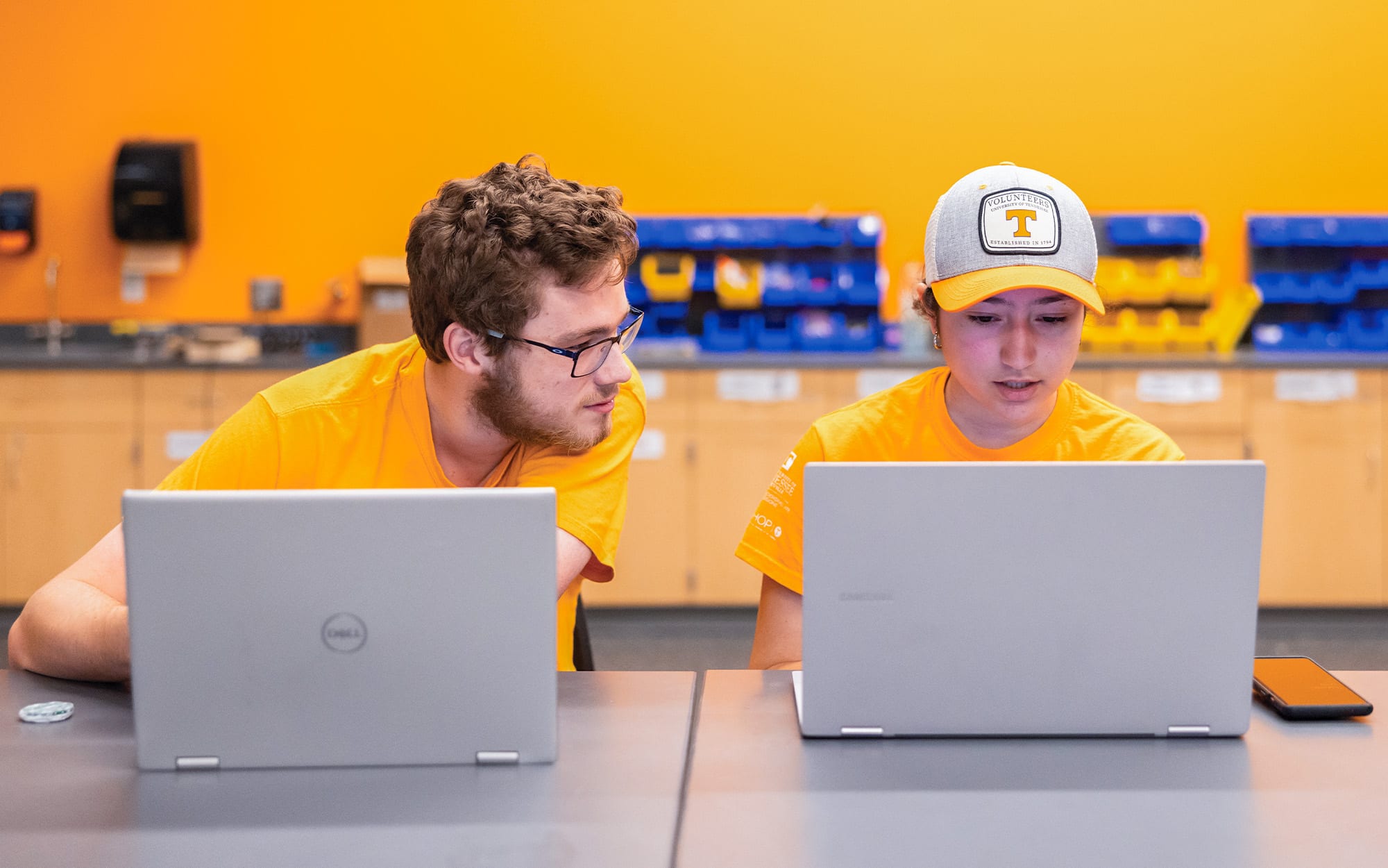 Two students work on their computer in the engage active learning classroom. 