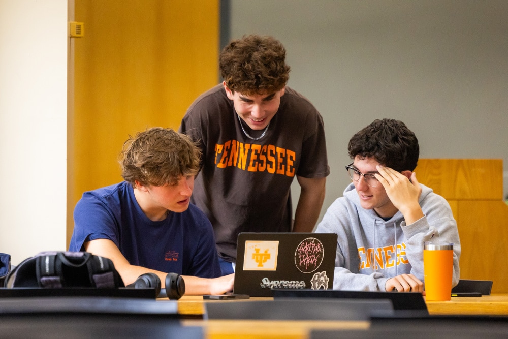 Three students studying in the library during Finals Week