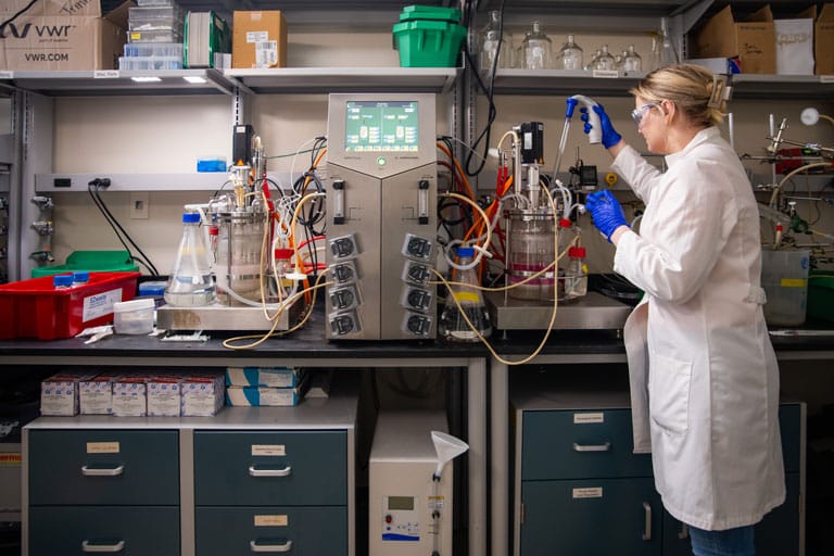 PhD student Carrie Sanford starts an experiment in the bioreactor room in Senter Hall