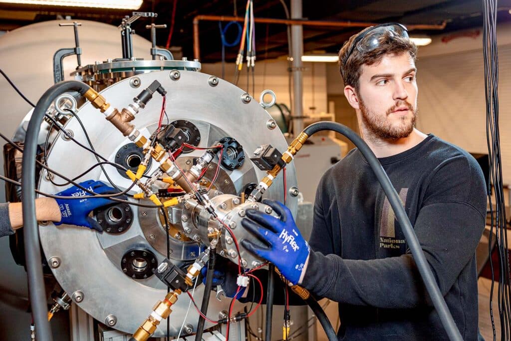 Aerospace engineering PhD student works with the equipment for the ArcJet Tunnel.