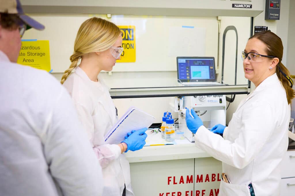 Colleen Crouch works with two students in her lab